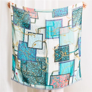 Detail of vintage chain print scarf with floral patterns and pom-pom tassel trim