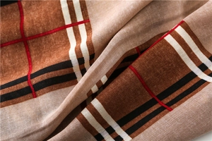 Macro view of plaid pattern scarf showing soft woven texture and layered fabric folds
