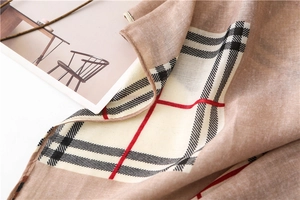 Close-up of beige plaid scarf showing soft fabric texture and classic grid pattern