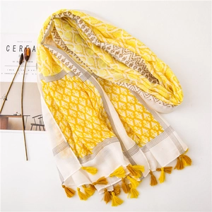 Detail of yellow cotton linen scarf with geometric diamond patterns and fringe trim