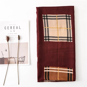 Close-up of burgundy cotton linen scarf with classic check pattern on a minimalist background