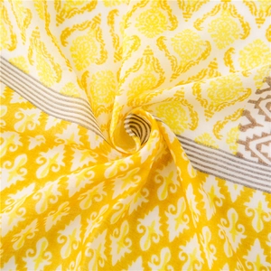 Detailed close-up of yellow and white bohemian linen scarf with retro damask print