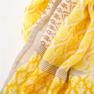 Macro detail of Bohemian linen scarf showing damask patterns and yellow woven texture