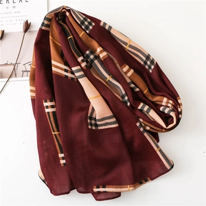 Flat lay of a classic burgundy plaid scarf with khaki accents and soft woven texture