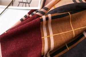 Detail of soft plaid scarf fabric with classic burgundy and caramel check pattern