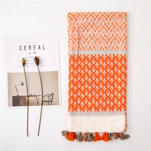 Detail of bohemian cotton linen scarf featuring vintage patterns and orange fringe tassels