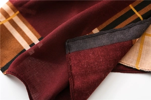 Close-up of retro plaid scarf showing burgundy fabric texture and fine knit edge details