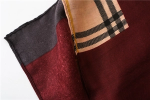 Close-up of color-block plaid scarf showing fine fabric texture and burgundy grey patterns