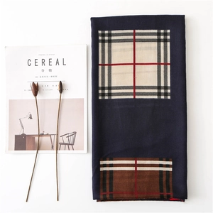 Flat lay detail of a classic plaid cotton linen scarf with elegant check patterns