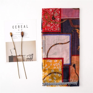Detail shot of vintage chain print scarf with tassel edge on a minimalist background