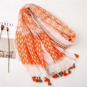 Detail of bohemian print scarf with orange tassels and intricate geometric patterns