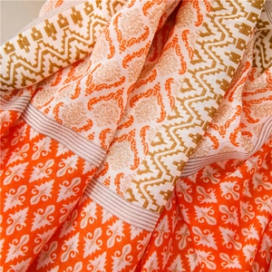 Detail of bohemian cotton linen shawl with orange damask patterns and tassel texture