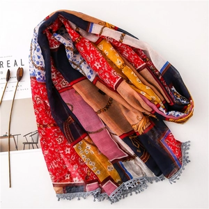 Close-up of vintage chain print scarf featuring colorful patterns and small ball tassels