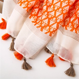 Detailed macro view of bohemian cotton linen scarf with vibrant fringe and iris patterns