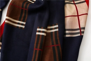Macro detail of soft cotton linen fabric showing the classic blue and red plaid pattern