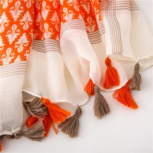 Macro detail of breathable cotton linen scarf with orange Damask prints and braided tassels