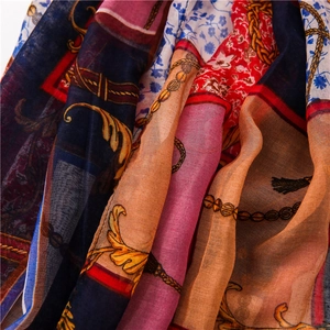 Close-up of vintage chain print scarf showing golden baroque patterns and fringe details