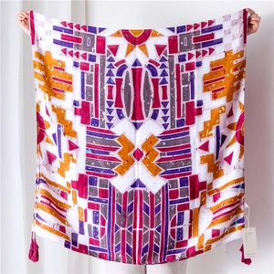 Detailed view of colorful geometric print beach shawl with decorative purple tassels