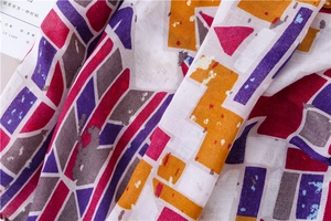 Macro detail of breathable ethnic shawl showing geometric prints and cotton-linen texture