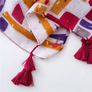 Detailed view of bohemian beach shawl with vibrant geometric prints and pink fringe tassels