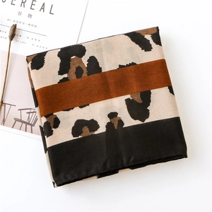 Detailed view of leopard print cotton-linen scarf with silky texture and striped edge