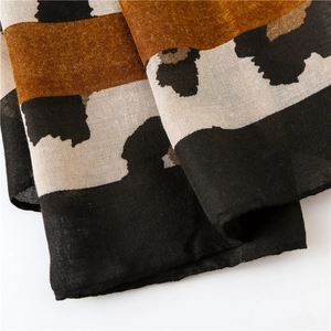 Close-up of leopard print linen scarf fabric showing fine texture and striped detail