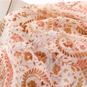 Détail macro d'une écharpe en coton et lin avec des motifs paisley et floraux