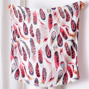 Detailed view of colorful feather print scarf with metallic thread and fringed edges
