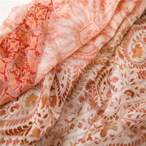 Vue détaillée d'une écharpe à motif cachemire avec tissage de fils dorés et fleurs