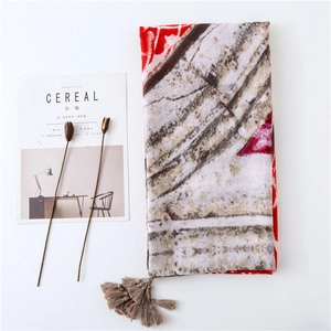Detail of vintage geometric pattern and tassel trim on lightweight summer scarf