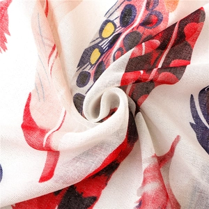 Macro view of lightweight cotton scarf showing colorful feather print and fine fabric texture