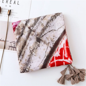 Detail of vintage geometric pattern shawl with elegant red marble print and soft tassels