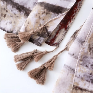 Detail of ethnic geometric flame pattern scarf with intricate handmade tassels fringe