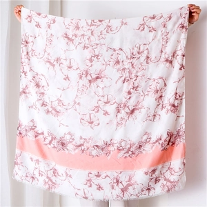 Detail view of floral print shawl with rose patterns and pink border tassels