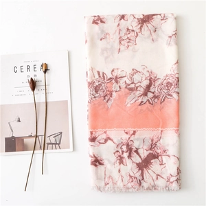 Vintage floral scarf with coral peonies and fringe tassels displayed on magazines