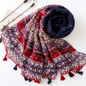 Bohemian floral cotton linen scarf with red tassels shown with artistic magazine props