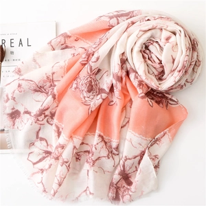 Pink orange floral scarf with frayed edges and natural crinkle texture on white background