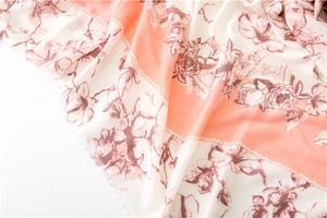Detail of lightweight printed scarf with floral pattern and natural frayed edges