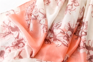 Detailed macro of pink and white scarf fabric with red flowers and gold glitter accents