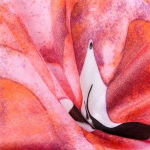 Gros plan détaillé du motif flamant rose et du tissage en lin sur écharpe rose doux