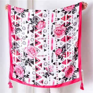 Detail eines Baumwoll-Leinen-Schals mit rosa Rosen, geometrischen Mustern und roten Quasten