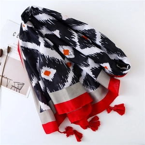 Écharpe longue aux motifs ikat noir et rouge avec d'élégants glands rouges aux coins