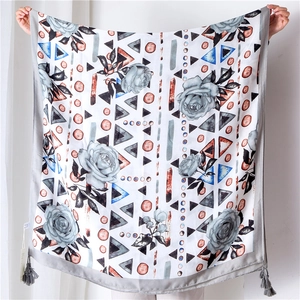 Detailansicht eines großen Schals mit Blumenmuster, Quasten und geometrischen Formen