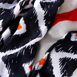 Écharpe à motifs géométriques noir et rouge effet coton-lin, vue détaillée drapée