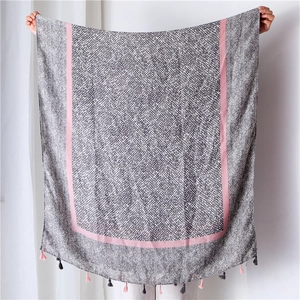 Detail of linen scarf featuring herringbone pattern, dot texture and bicolor tassels