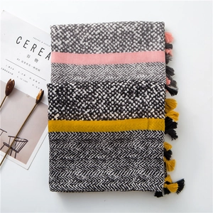 Detailed view of folded cotton linen scarves with leopard prints and fringe tassels