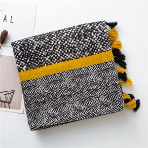 Detail of cotton linen scarf with yellow tassels, polka dot and herringbone patterns