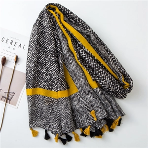 Detailed texture of cotton linen scarf with herringbone patterns and yellow tassel fringe