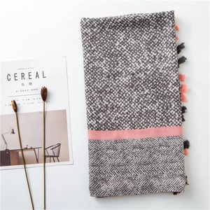 Close-up of spring linen scarf with gray leopard patterns, pink stripes, and tassel fringe
