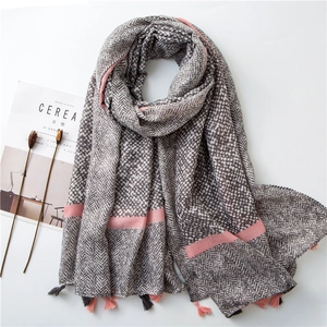 Detail of cotton linen scarf with herringbone pattern, polka dots and tassel balls